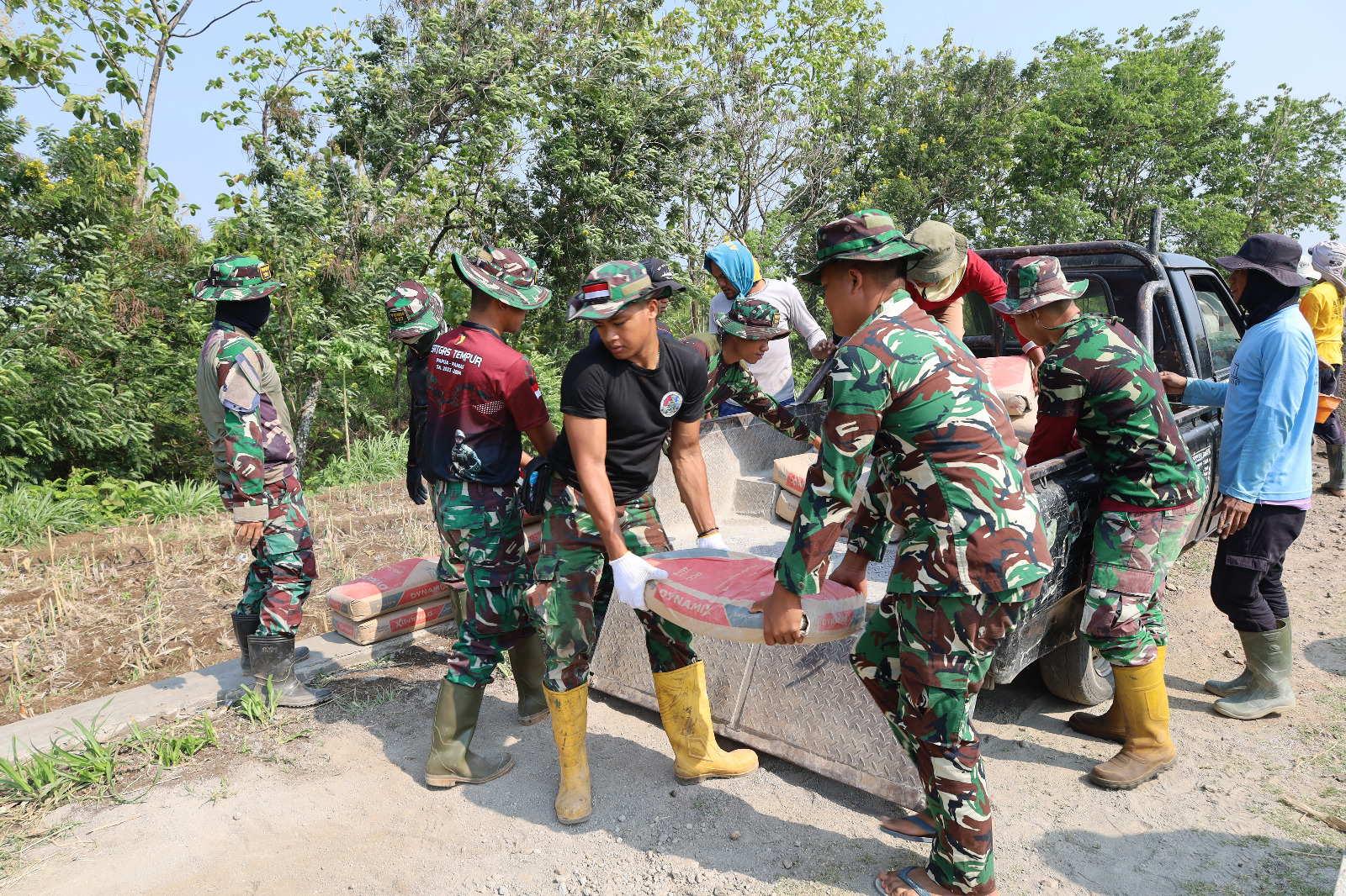 Satgas TMMD ke-126 Kodim 0804/Magetan dan Warga Semangat Bongkar Muatan Material Cor Jalan di Desa Kembangan
